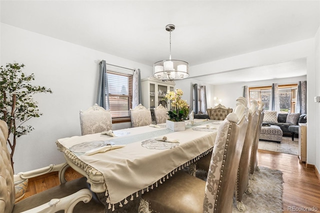 dining room with baseboards, wood finished floors, and a chandelier