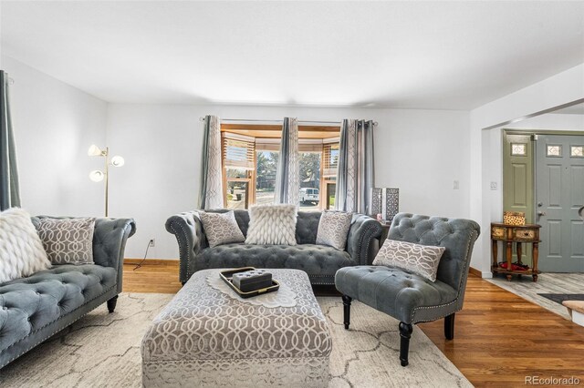 living area featuring baseboards and wood finished floors