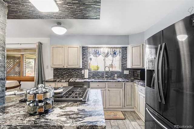 3191 S Holly Pl, Denver, CO 80222 - kitchen with fridge with ice dispenser, a sink, plenty of natural light, and light wood-style floors