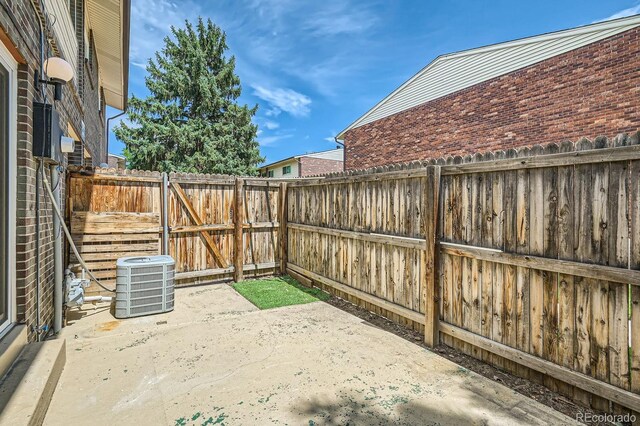 view of patio / terrace with a gate, central AC unit, and a fenced backyard