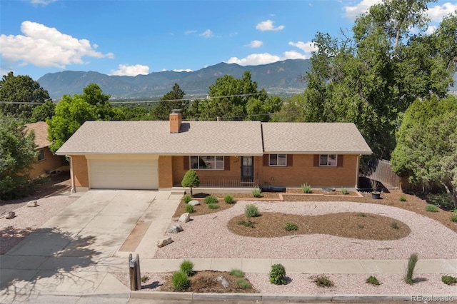 1411 Acacia Dr, Colorado Springs, CO 80907 - single story home with driveway, brick siding, a garage, and a chimney
