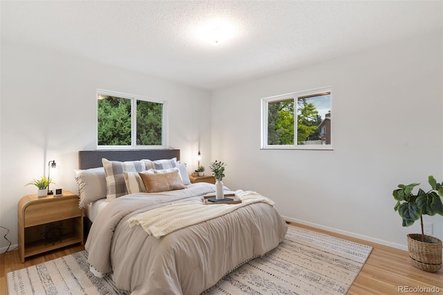 1411 Acacia Dr, Colorado Springs, CO 80907 - bedroom with light wood-type flooring and a textured ceiling