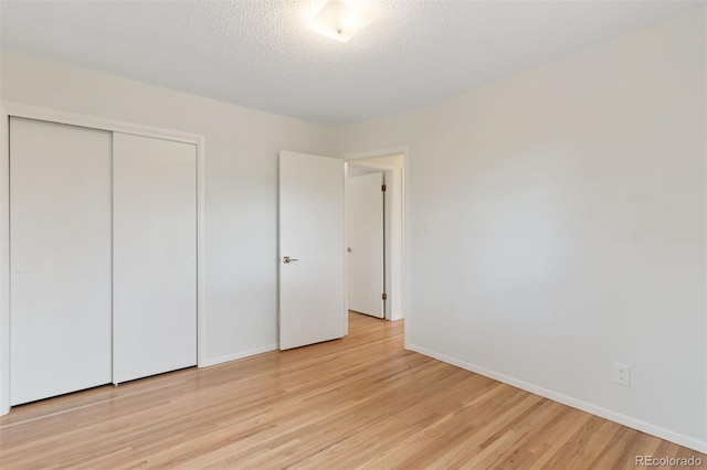 1411 Acacia Dr, Colorado Springs, CO 80907 - unfurnished bedroom with light wood-style flooring, a closet, and a textured ceiling