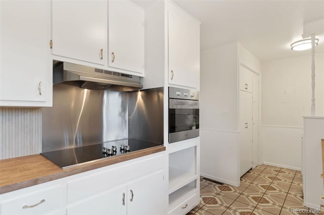 1411 Acacia Dr, Colorado Springs, CO 80907 - kitchen featuring under cabinet range hood, oven, black electric cooktop, and white cabinets