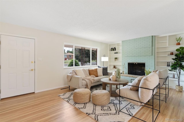 1411 Acacia Dr, Colorado Springs, CO 80907 - living room featuring light wood-type flooring, a fireplace, a textured ceiling, and built in features