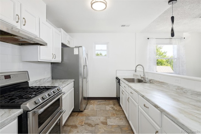 1455 W Alaska Pl, Denver, CO 80223 - kitchen featuring stainless steel appliances, under cabinet range hood, white cabinetry, tasteful backsplash, and light stone finish flooring
