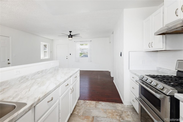 1455 W Alaska Pl, Denver, CO 80223 - kitchen featuring double oven range, ceiling fan, white cabinets, decorative backsplash, and a textured ceiling