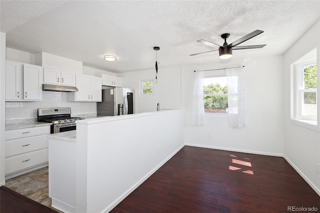 1455 W Alaska Pl, Denver, CO 80223 - kitchen featuring appliances with stainless steel finishes, under cabinet range hood, a textured ceiling, white cabinetry, and light countertops