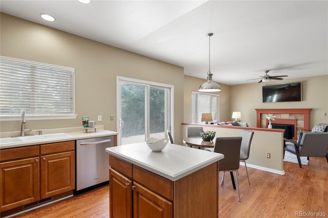 3232 Cimarron Pl, Superior, CO 80027 - kitchen with stainless steel dishwasher, light wood-style flooring, ceiling fan, a fireplace, and light countertops