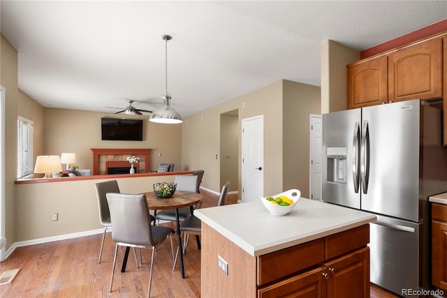 3232 Cimarron Pl, Superior, CO 80027 - kitchen featuring stainless steel fridge with ice dispenser, a ceiling fan, light wood-style floors, a tiled fireplace, and light countertops