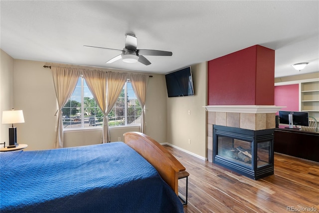 3232 Cimarron Pl, Superior, CO 80027 - bedroom featuring wood finished floors, a tiled fireplace, and a ceiling fan