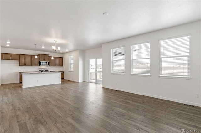 18162 Coppermallow Trl, Parker, CO 80134 - unfurnished living room with a chandelier and dark wood-style floors