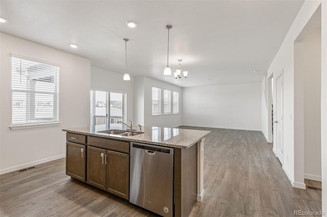 18162 Coppermallow Trl, Parker, CO 80134 - kitchen with dishwasher, a chandelier, wood finished floors, decorative light fixtures, and light stone countertops