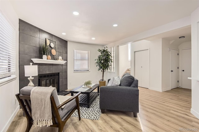 living room with light hardwood / wood-style floors and a tile fireplace