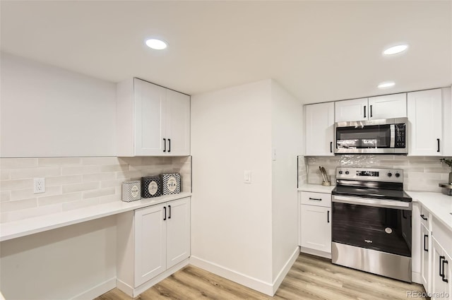 kitchen featuring white cabinetry, backsplash, light hardwood / wood-style flooring, and appliances with stainless steel finishes