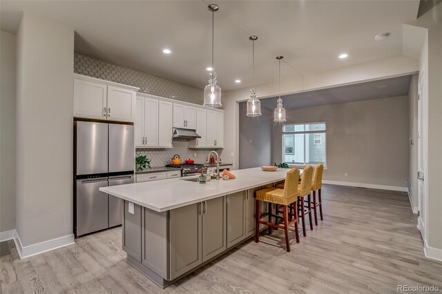 5185 Vivian St, Wheat Ridge, CO 80033 - kitchen with appliances with stainless steel finishes, tasteful backsplash, light wood-style floors, a large island, and recessed lighting