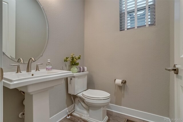 5185 Vivian St, Wheat Ridge, CO 80033 - half bath with toilet, baseboards, wood finished floors, and a sink