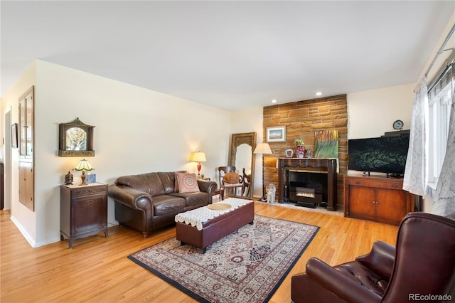 living room with a fireplace and light wood-type flooring