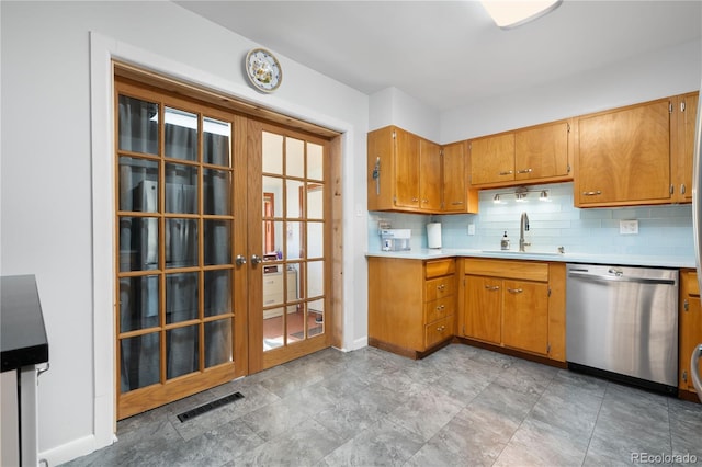 kitchen featuring backsplash, dishwasher, and sink