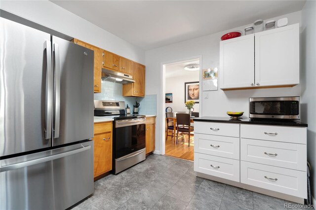 kitchen featuring backsplash, white cabinets, and stainless steel appliances