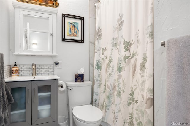 bathroom with decorative backsplash, toilet, walk in shower, and vanity