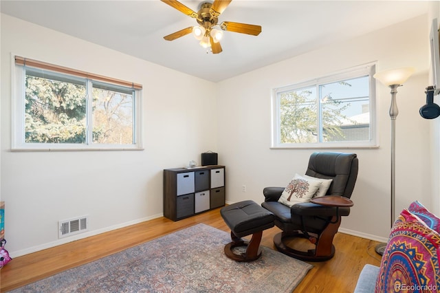 living area with ceiling fan and light wood-type flooring