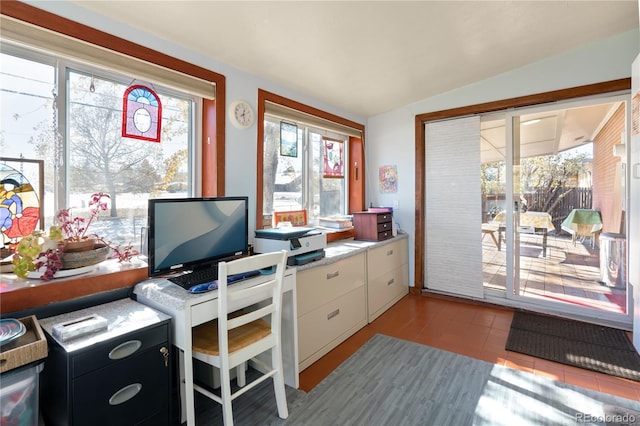 office space featuring plenty of natural light, light tile patterned floors, and lofted ceiling