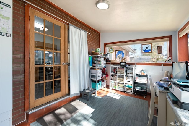 interior space with dark hardwood / wood-style floors, brick wall, and lofted ceiling