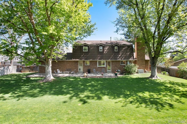 10366 E Ida Ave, Greenwood Village, CO 80111 - back of property with a patio, central AC unit, a chimney, and brick siding