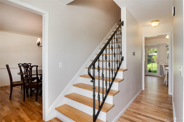 10366 E Ida Ave, Greenwood Village, CO 80111 - staircase featuring wood finished floors, baseboards, and a chandelier