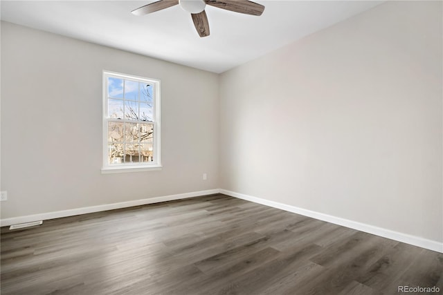 spare room featuring dark wood-type flooring and ceiling fan