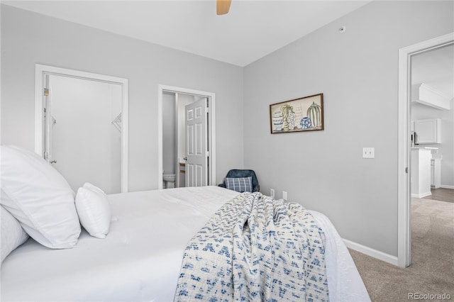 bedroom with ceiling fan, ensuite bathroom, a walk in closet, and carpet flooring