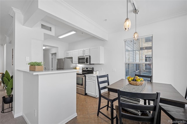 kitchen with white cabinetry, kitchen peninsula, stainless steel appliances, decorative light fixtures, and crown molding