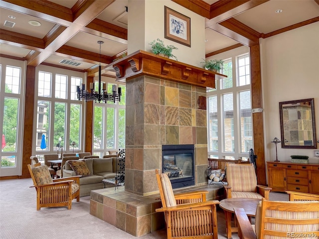 carpeted living room with coffered ceiling, a fireplace, a chandelier, crown molding, and beam ceiling