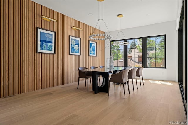 171 S Dexter St, Denver, CO 80246 - dining area with light wood-type flooring, a chandelier, and wooden walls