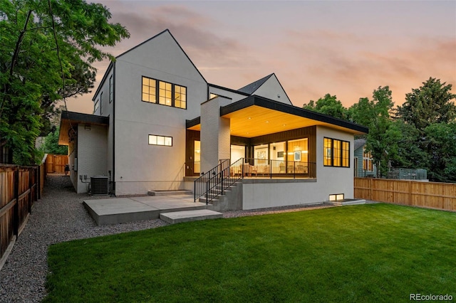 171 S Dexter St, Denver, CO 80246 - back of house at dusk with a fenced backyard, stucco siding, and a patio area