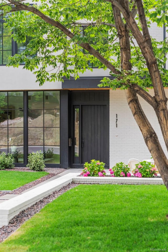 171 S Dexter St, Denver, CO 80246 - view of exterior entry with brick siding and a lawn