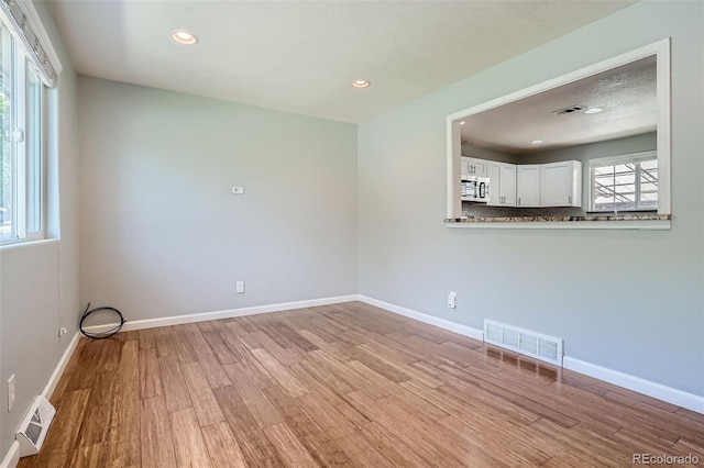 empty room featuring a textured ceiling and light wood-type flooring