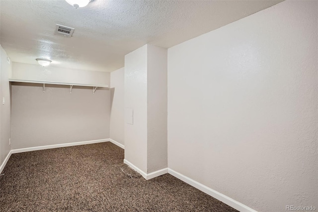 walk in closet with dark colored carpet