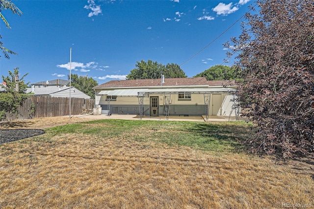 back of property featuring a lawn and a patio area