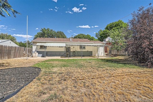 rear view of house featuring a lawn and a patio area