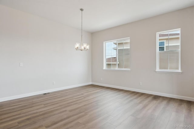 4978 Hickory Oaks St, Castle Rock, CO 80104 - unfurnished room with wood finished floors, a chandelier, and healthy amount of natural light