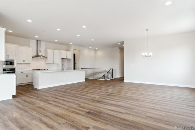 4978 Hickory Oaks St, Castle Rock, CO 80104 - kitchen with wall chimney exhaust hood, appliances with stainless steel finishes, open floor plan, a sink, and a chandelier