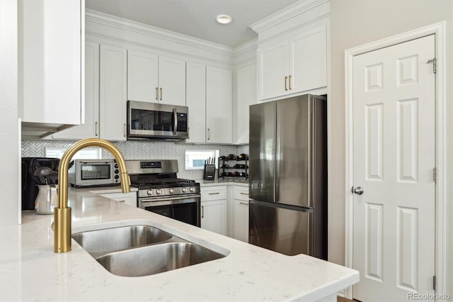 3178 Geneva Ct, Denver, CO 80238 - kitchen featuring appliances with stainless steel finishes, white cabinetry, light stone countertops, and crown molding