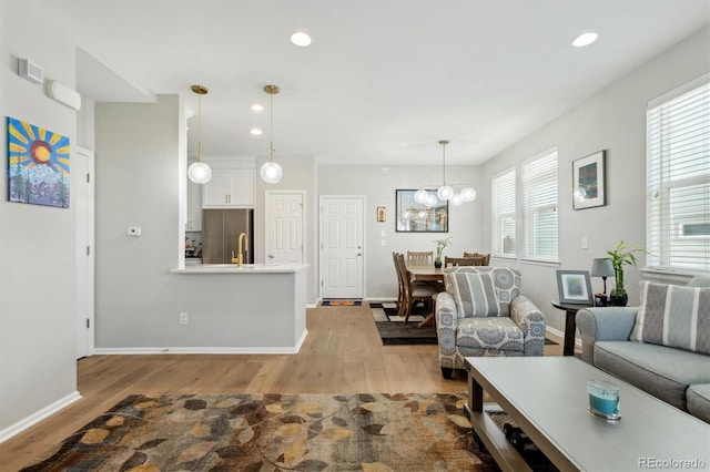 3178 Geneva Ct, Denver, CO 80238 - living area with light wood finished floors, healthy amount of natural light, recessed lighting, and baseboards