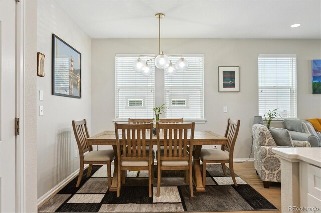 3178 Geneva Ct, Denver, CO 80238 - dining space featuring wood finished floors, a chandelier, baseboards, and healthy amount of natural light