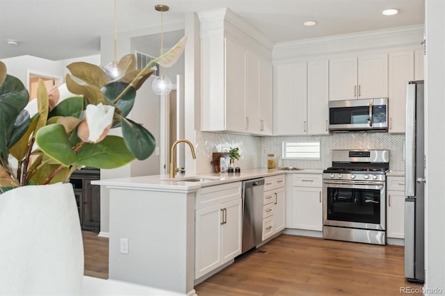 3178 Geneva Ct, Denver, CO 80238 - kitchen with appliances with stainless steel finishes, white cabinetry, wood finished floors, a peninsula, and recessed lighting