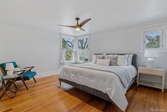 bedroom featuring baseboards, ceiling fan, and light wood-style flooring