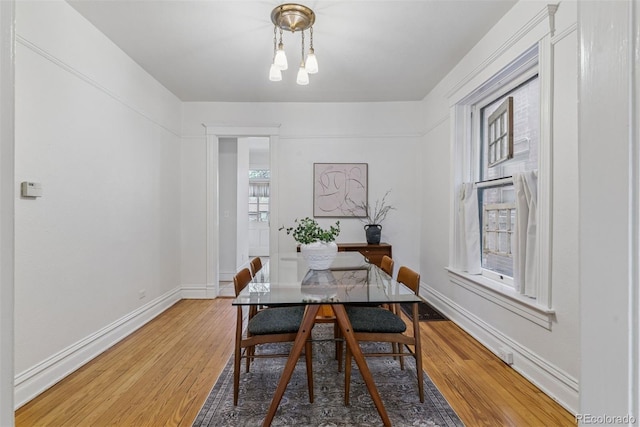 dining space featuring baseboards and light wood-type flooring
