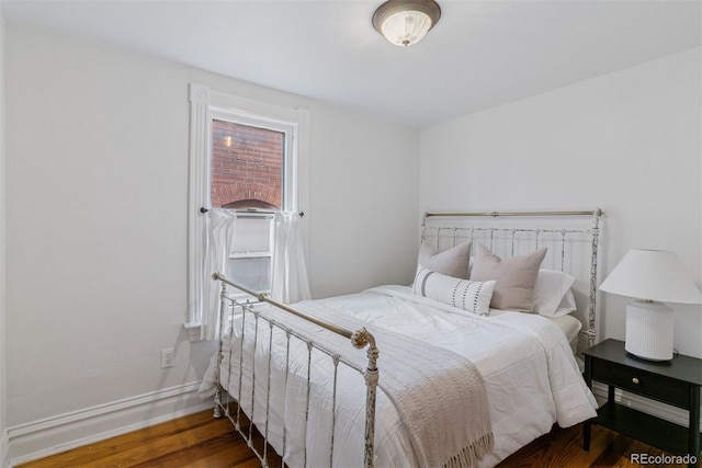 bedroom with baseboards and wood finished floors